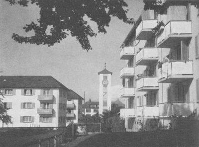 Blick von der Bruggmühlestrasse mit evangelischer Kirche, rechts «Cervelatblock». So genannt, weil die neuen Wohnungen im Verhältnis zu Altwohnungen so teuer waren, dass sich die Mieten nur leisten konnte, wer sich von Cervelats und Brot ernährte.